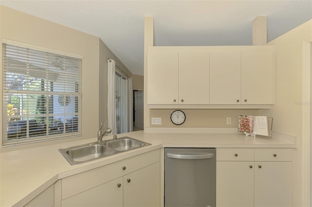 kitchen featuring stainless steel dishwasher, a sink, white cabinetry, and light countertops
