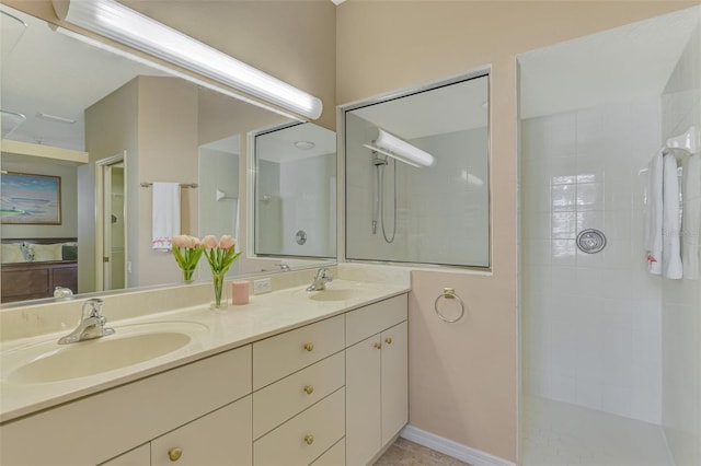 full bath featuring double vanity, a tile shower, and a sink