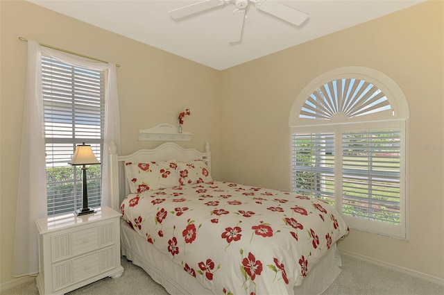 bedroom featuring multiple windows, light carpet, and baseboards