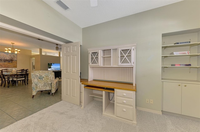 office featuring an inviting chandelier, light tile patterned flooring, visible vents, vaulted ceiling, and light carpet