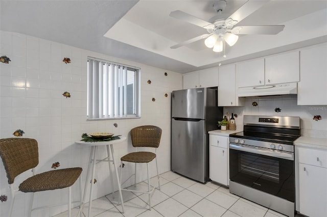 360 Base Ave E Unit 413, Venice, FL 34285 - kitchen featuring white cabinets, stainless steel appliances, light countertops, under cabinet range hood, and light tile patterned floors