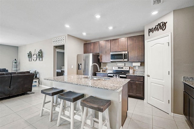 4523 Birdsong Dr, Palmetto, FL 34221 - kitchen featuring light tile patterned floors, a kitchen breakfast bar, a sink, and appliances with stainless steel finishes