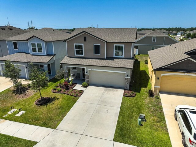 4523 Birdsong Dr, Palmetto, FL 34221 - view of front of home with a garage, driveway, stone siding, a shingled roof, and a front yard