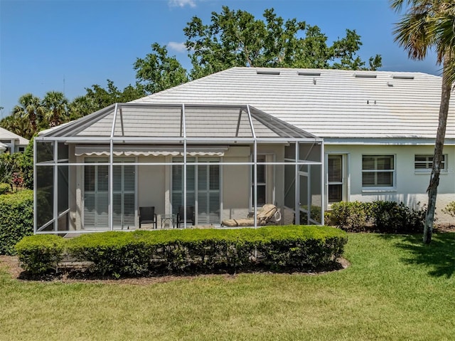 back of property featuring a lawn and stucco siding