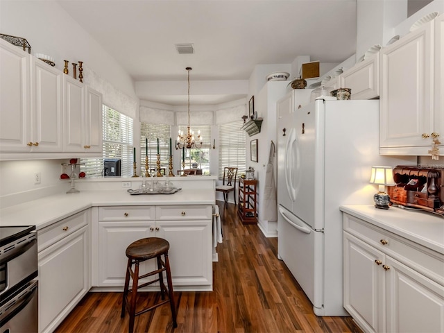 kitchen featuring white cabinets, a peninsula, and visible vents
