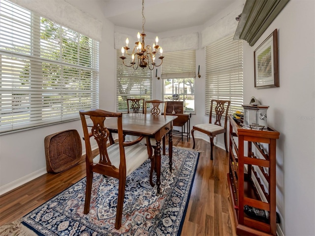 dining area with an inviting chandelier, baseboards, and wood finished floors