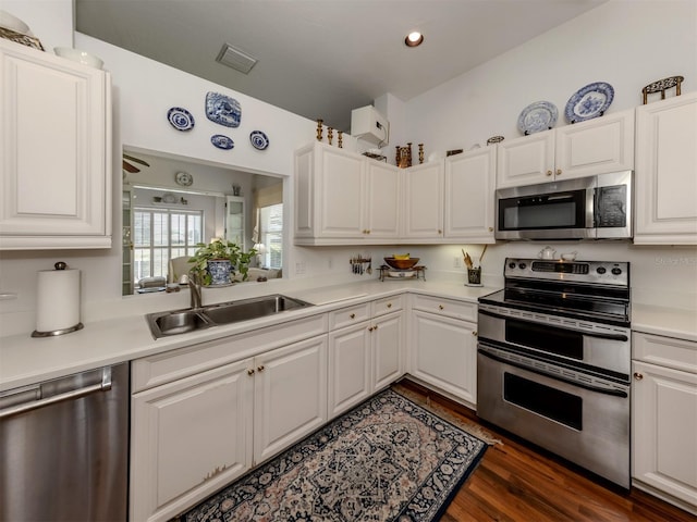 kitchen with a sink, appliances with stainless steel finishes, white cabinetry, and light countertops