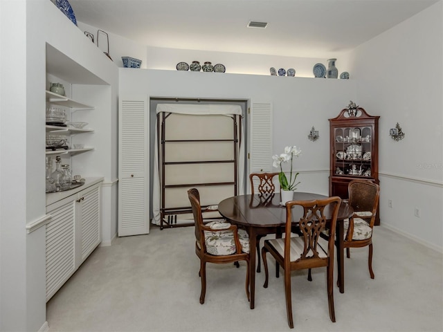 dining space featuring visible vents and light colored carpet