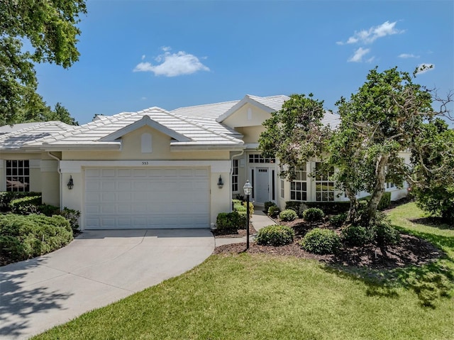 view of front of house featuring concrete driveway, stucco siding, an attached garage, and a front yard