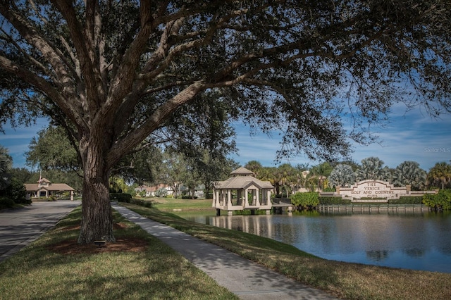 surrounding community featuring a lawn, a water view, and a gazebo