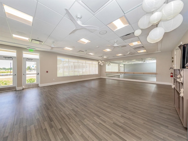 unfurnished room with baseboards, a paneled ceiling, and dark wood-style floors