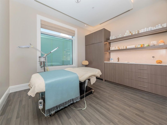 bedroom with baseboards and wood finished floors
