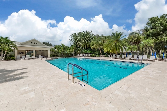 pool with fence and a patio area