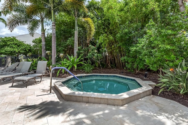 view of swimming pool featuring fence, a community hot tub, and a patio area