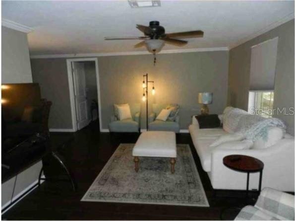 751 Arabian Cir, Nokomis, FL 34275 - living room featuring crown molding, a ceiling fan, wood finished floors, and baseboards