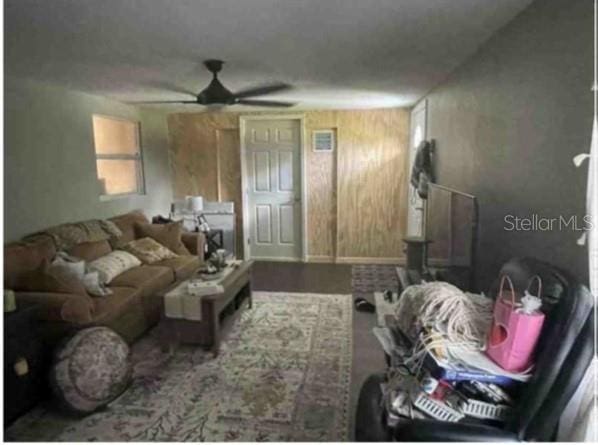 751 Arabian Cir, Nokomis, FL 34275 - living room featuring a ceiling fan and wooden walls
