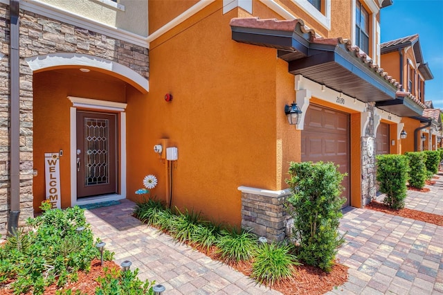 view of exterior entry with stone siding and stucco siding