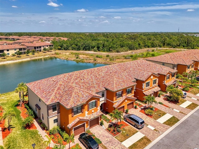 birds eye view of property with a view of trees and a water view