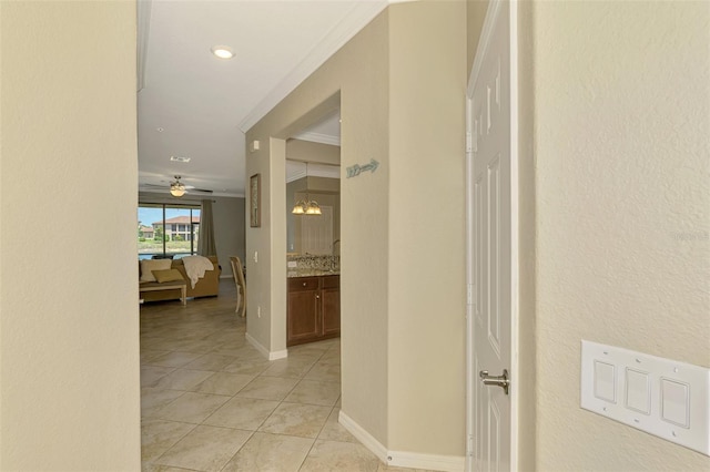 corridor featuring light tile patterned floors, crown molding, and recessed lighting