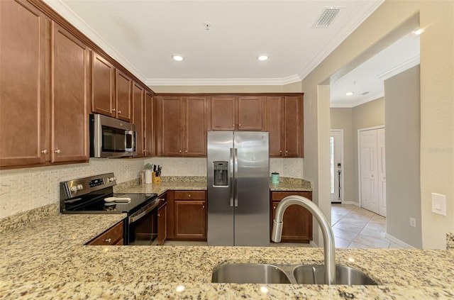 kitchen featuring a sink, stainless steel appliances, backsplash, visible vents, and ornamental molding