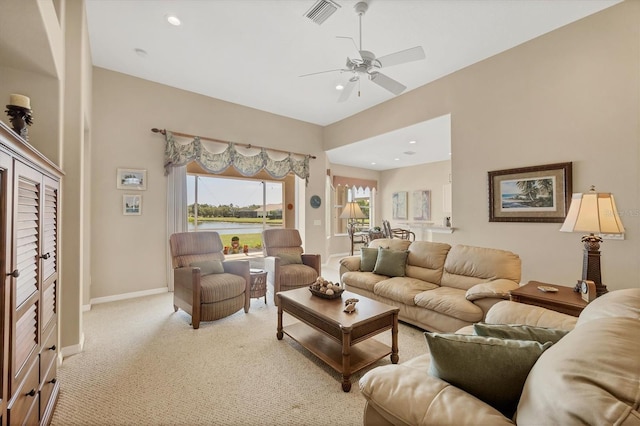 carpeted living area featuring a ceiling fan, visible vents, recessed lighting, and a water view