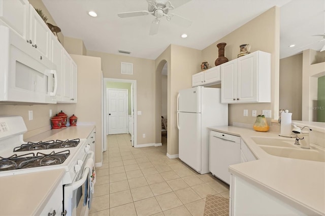 kitchen featuring arched walkways, a sink, white appliances, ceiling fan, and light tile patterned floors