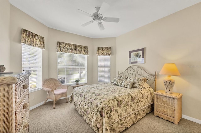 bedroom with light colored carpet, baseboards, and multiple windows