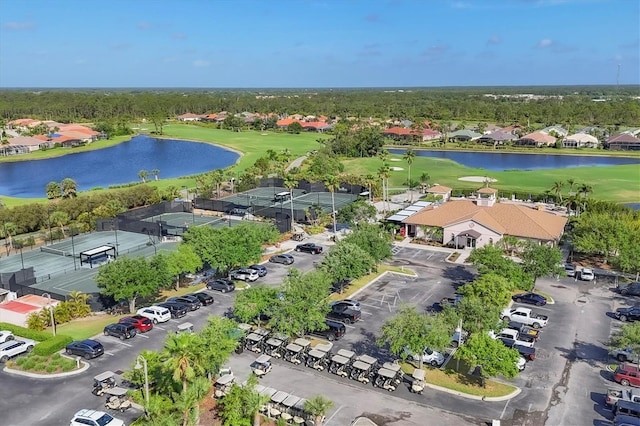 drone / aerial view with view of golf course, a residential view, and a water view