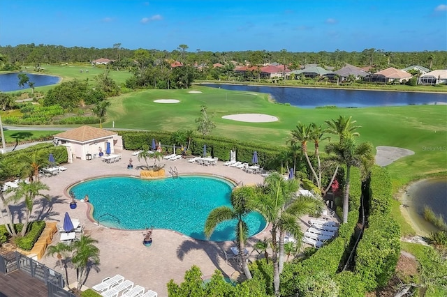 community pool featuring golf course view, fence, a water view, and a patio area