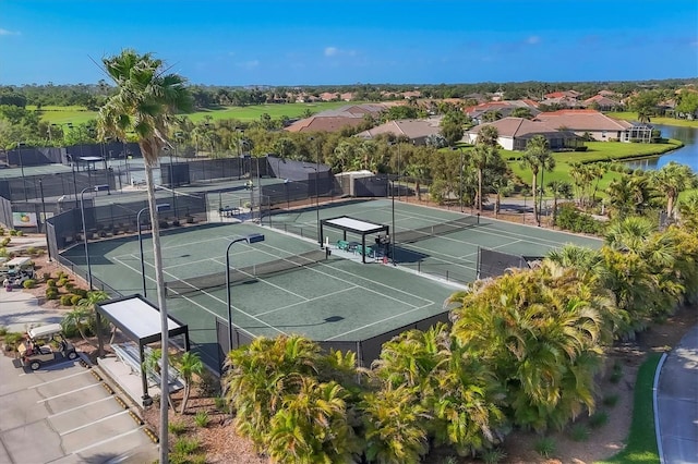 view of sport court featuring a water view and fence