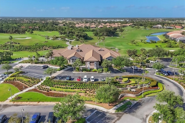 birds eye view of property with golf course view and a water view