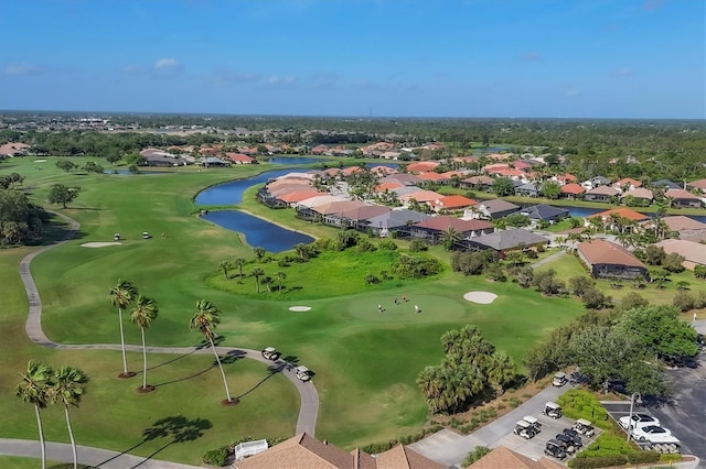 birds eye view of property featuring view of golf course, a water view, and a residential view