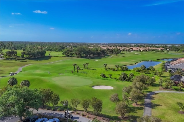 drone / aerial view featuring golf course view and a water view