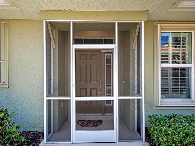 view of exterior entry with stucco siding