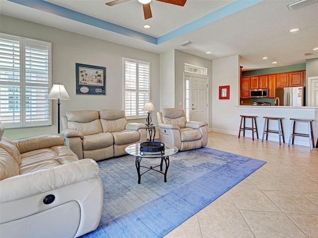 living room with visible vents, light tile patterned floors, a ceiling fan, and recessed lighting