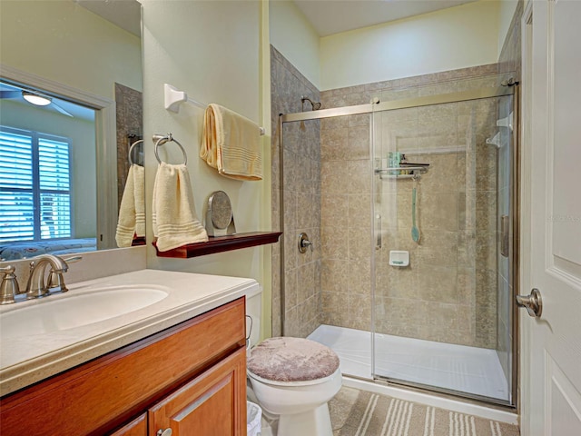 full bath featuring toilet, vanity, and a shower stall