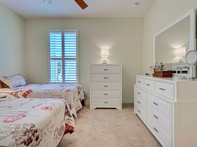 bedroom featuring light colored carpet and a ceiling fan