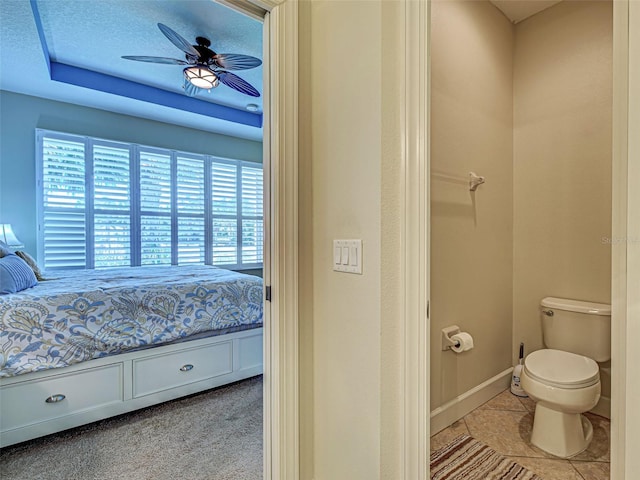 bathroom featuring toilet, ceiling fan, baseboards, and ensuite bath