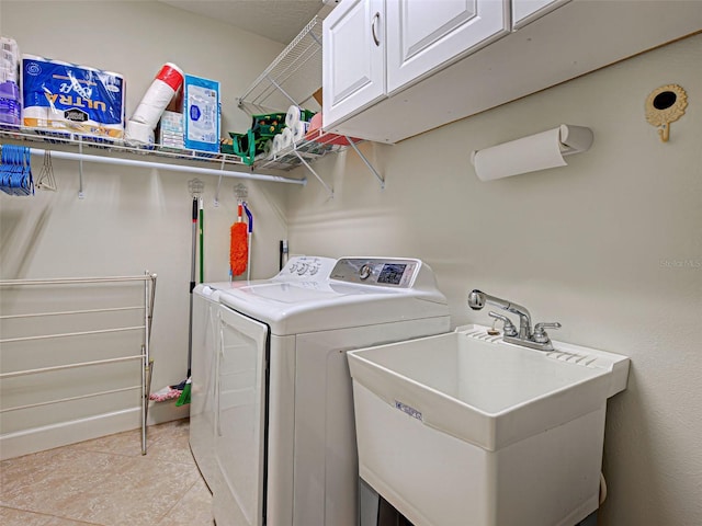 washroom with a sink, washing machine and clothes dryer, and cabinet space