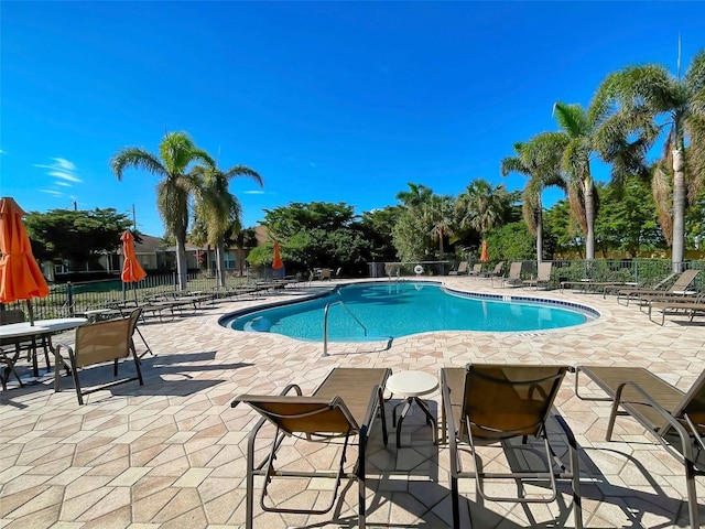 community pool featuring fence and a patio area