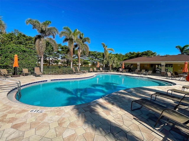 pool featuring fence and a patio area