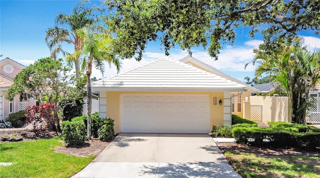 542 Clubside Cir Unit 20, Venice, FL 34293 - view of front of house featuring driveway, a garage, stucco siding, and fence