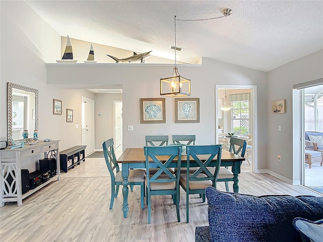 542 Clubside Cir Unit 20, Venice, FL 34293 - dining room featuring light wood-type flooring, baseboards, visible vents, a textured ceiling, and lofted ceiling