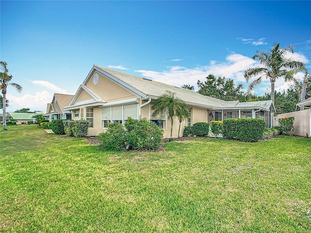 542 Clubside Cir Unit 20, Venice, FL 34293 - view of side of property with a sunroom, a yard, stucco siding, and fence