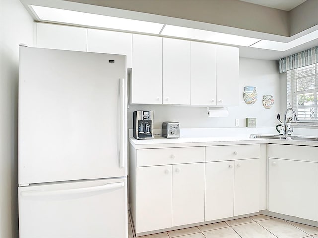 542 Clubside Cir Unit 20, Venice, FL 34293 - kitchen featuring white cabinetry, a sink, freestanding refrigerator, and light countertops