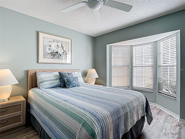 542 Clubside Cir Unit 20, Venice, FL 34293 - bedroom with a textured ceiling, ceiling fan, wood finished floors, and baseboards
