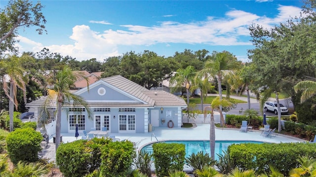 542 Clubside Cir Unit 20, Venice, FL 34293 - rear view of house featuring a patio, an outdoor pool, a tiled roof, fence, and french doors