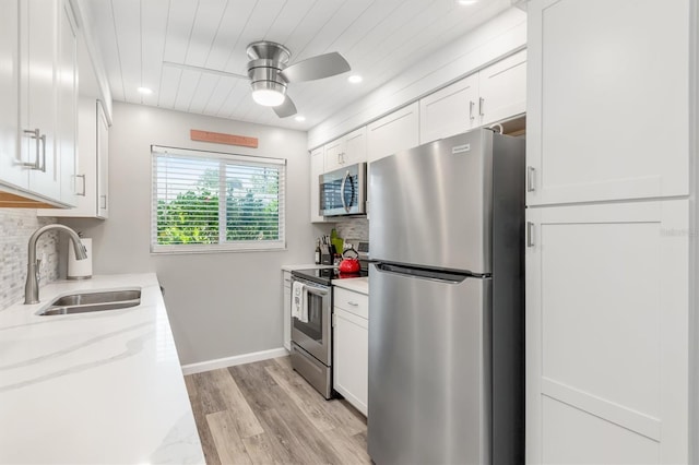 649 Tamiami Trl S Unit 106, Venice, FL 34285 - kitchen with a ceiling fan, white cabinetry, a sink, backsplash, and stainless steel appliances