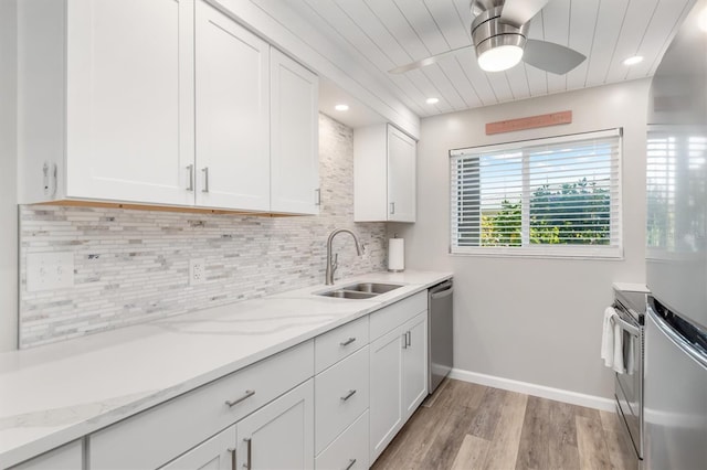 649 Tamiami Trl S Unit 106, Venice, FL 34285 - kitchen with appliances with stainless steel finishes, a sink, light wood finished floors, a ceiling fan, and white cabinetry