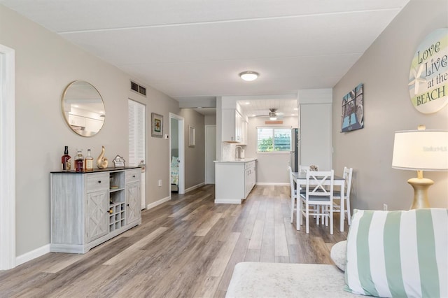 649 Tamiami Trl S Unit 106, Venice, FL 34285 - living room with baseboards, a ceiling fan, light wood-type flooring, and visible vents